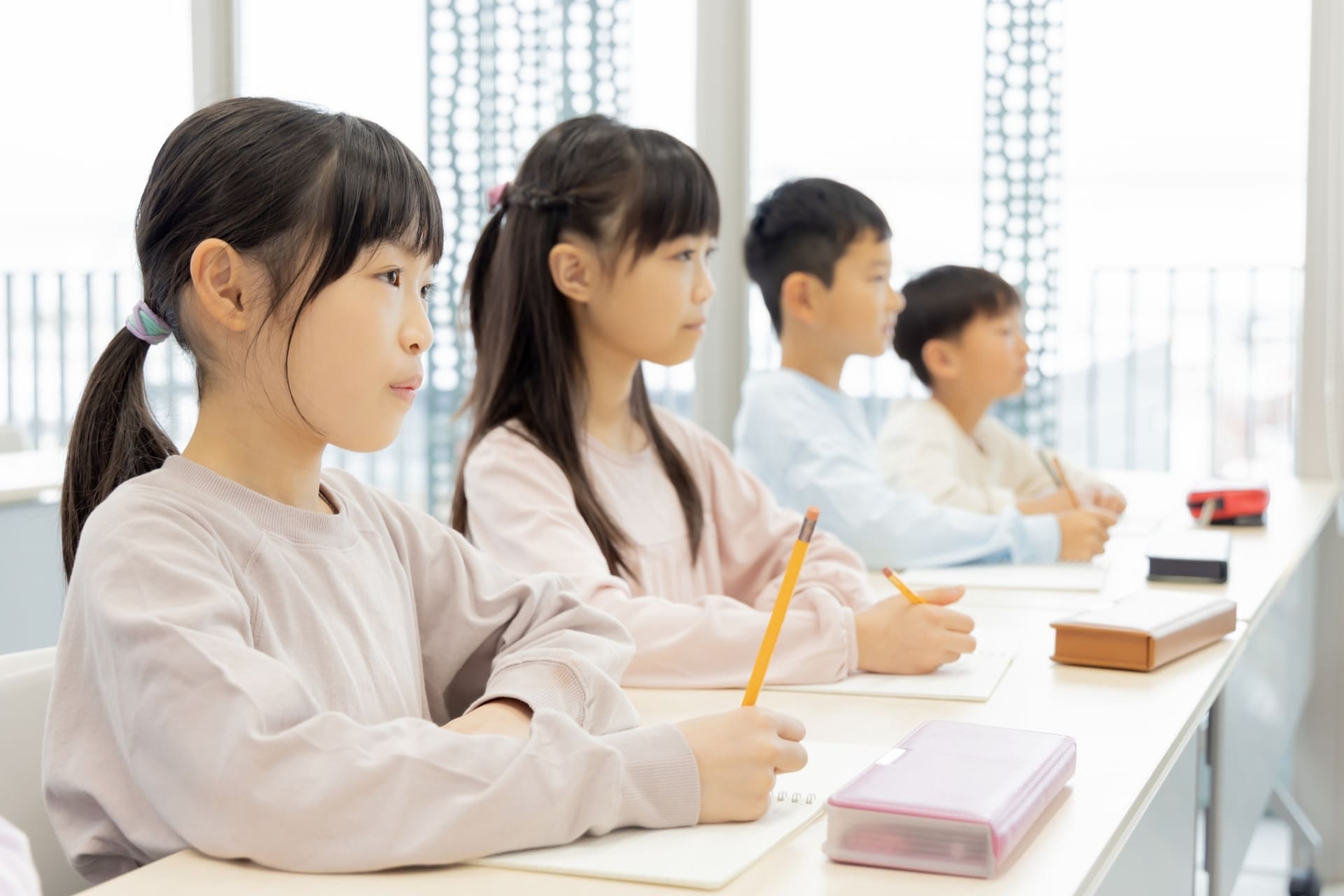 学習塾で勉強中の小学生男女